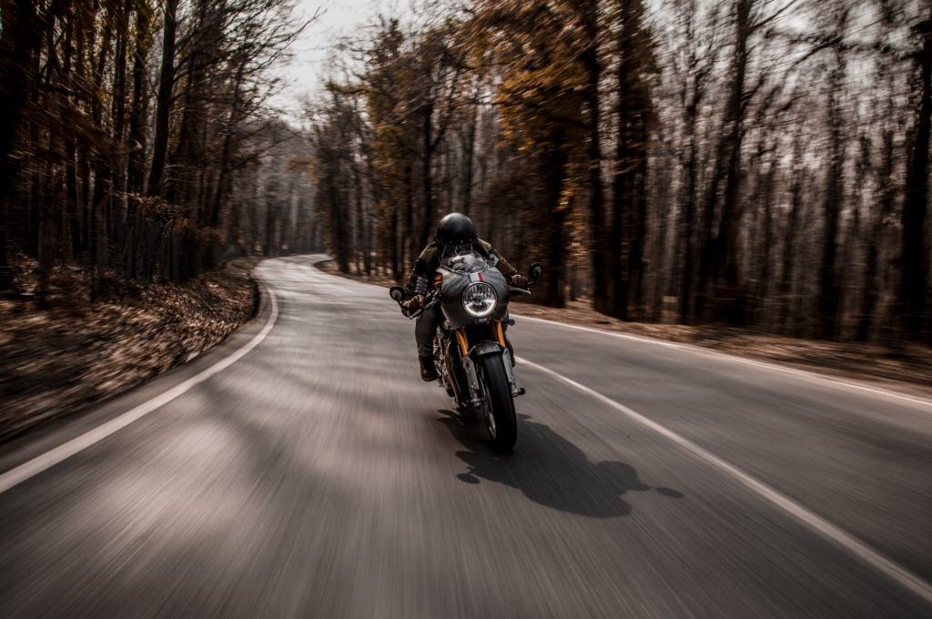 biker riding motorcycle in forest