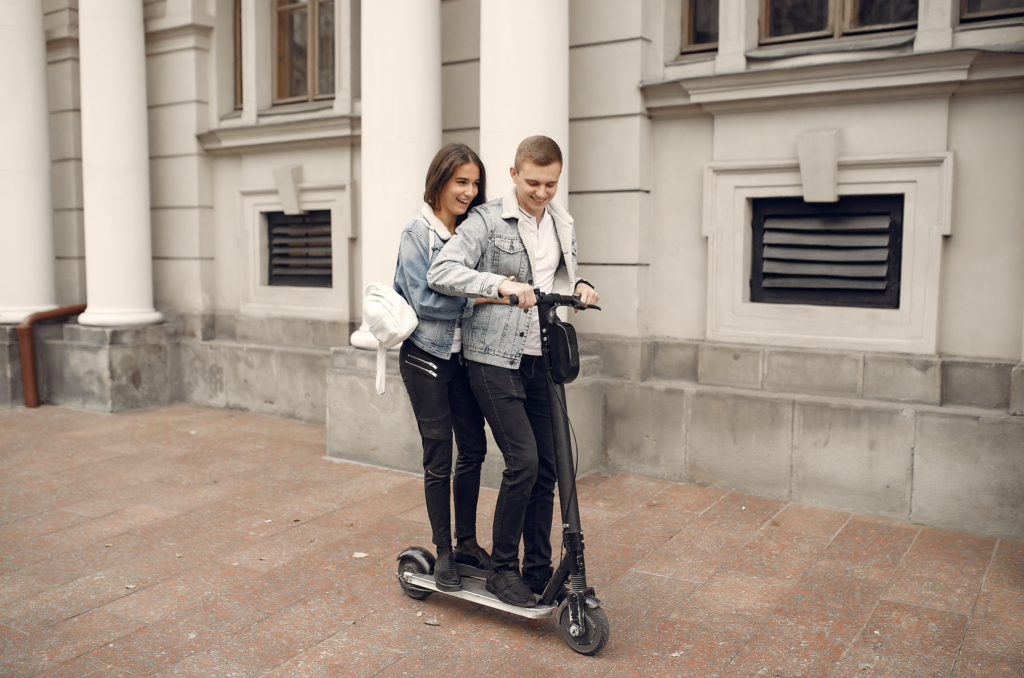 couple riding scooter in city